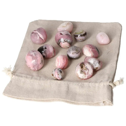 Pink Opal Tumbled Stones on Beige Cloth, Showcasing Soft Pastel Hues and Opalescent Sheen for Emotional Healing