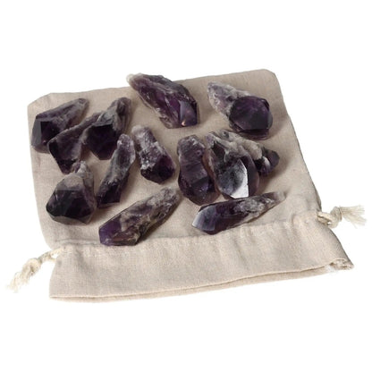 Set of Amethyst crystal tips on a beige cloth backdrop, ideal for reducing stress and enhancing concentration; a premium Sylvia Crystals product.