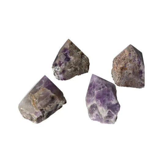 Four polished point chevron amethyst crystals from Sylvia Crystals, showcasing their stunning beauty and metaphysical properties.