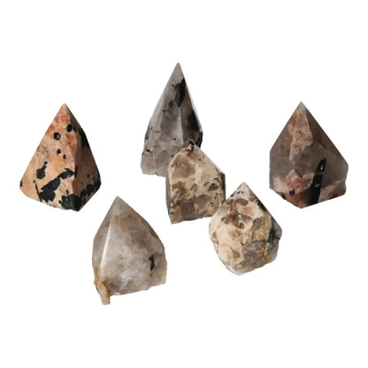 Group of polished point quartz crystals with black tourmaline inclusions, showcasing striking linear patterns.