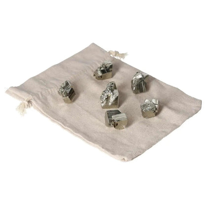 Alt Tag: Polished pyrite cubes and shapes on a fabric pouch, showcasing their golden luster and grounding energy.