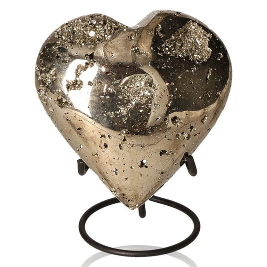 Heart-shaped pyrite stone with golden hue and metallic luster, symbolizing abundance and prosperity, on a display stand.