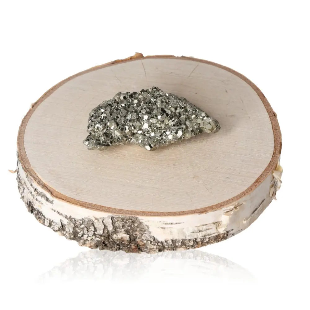 Pyrite druze crystal on a wooden slice, showcasing its radiant golden hue and metallic luster, symbolizing abundance and prosperity.