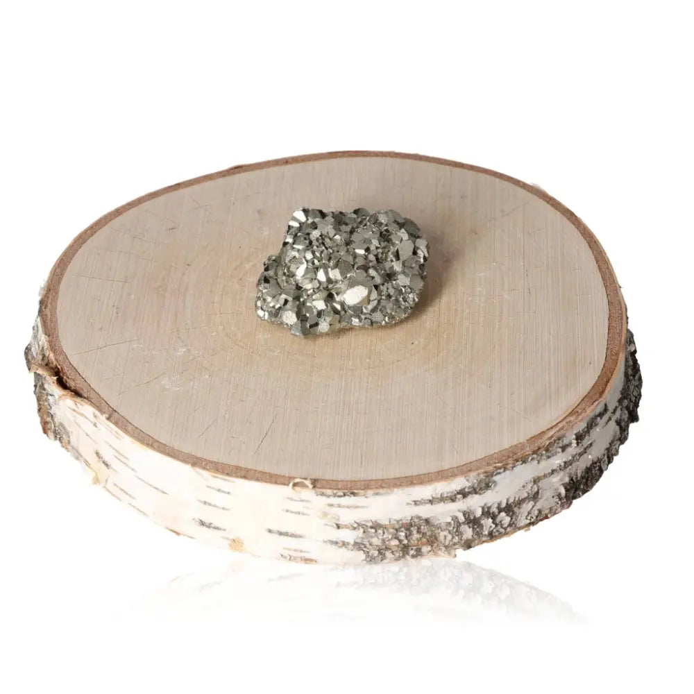 Pyrite druze mineral with metallic luster on a wooden slice, symbolizing prosperity and abundance.