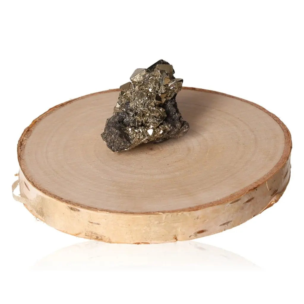 Pyrite druzy stone with metallic luster on wooden display, symbolizing wealth and prosperity.