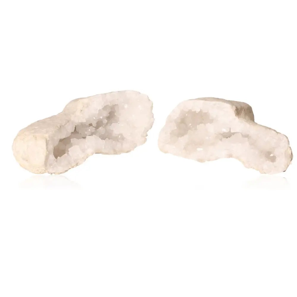 Two halves of a quartz geode displaying sparkling white crystals inside.