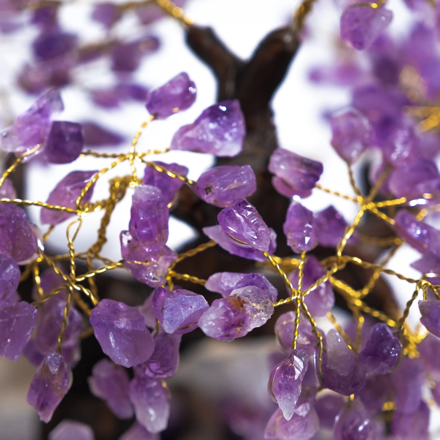 Close-up of handcrafted amethyst crystal bonsai tree with gemstone leaves, promoting tranquility and spiritual harmony.
