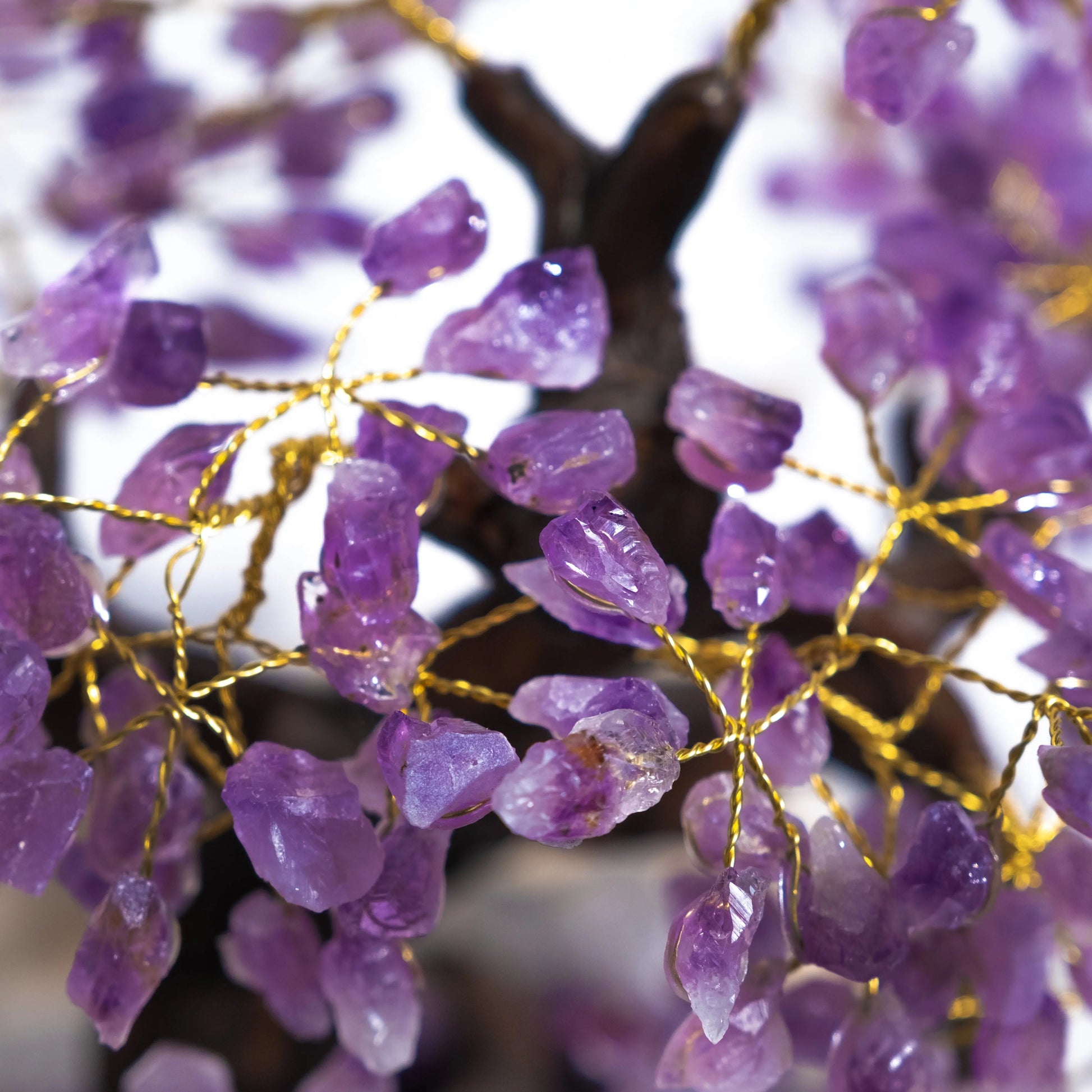 Close-up of handcrafted amethyst crystal bonsai tree with gemstone leaves, promoting tranquility and spiritual harmony.
