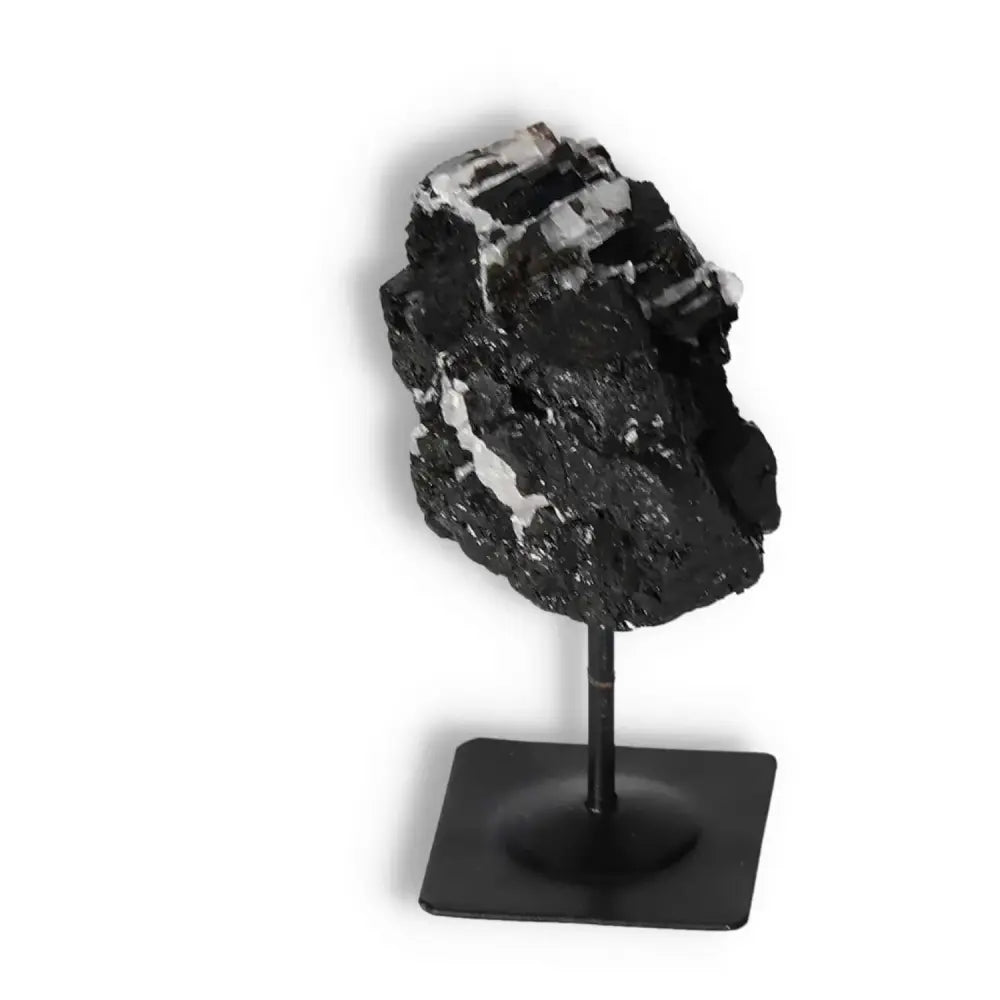 Rough black tourmaline crystal on metal stand, offers elegance and energy cleansing, premium quality by Sylvia Crystals.