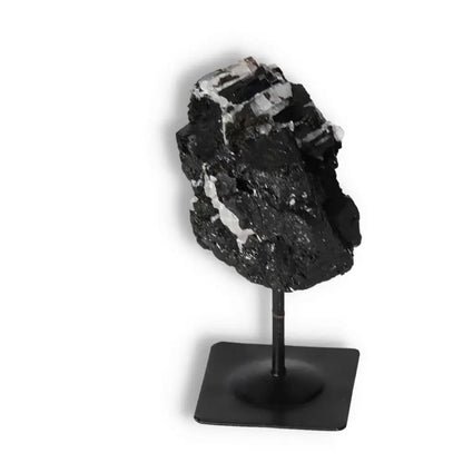 Rough black tourmaline crystal on metal stand, offers elegance and energy cleansing, premium quality by Sylvia Crystals.