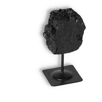 Rough Black Tourmaline on sleek metal stand for modern and traditional home interiors, offering protection and tranquility.