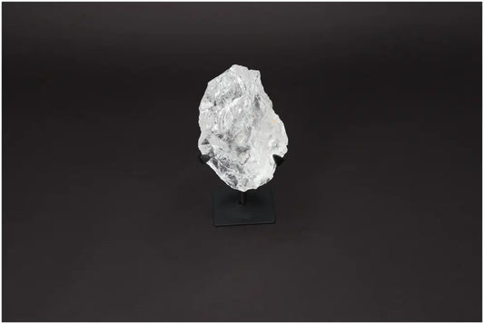 Rough Lemurian Clear Quartz Crystal on black metal stand for spiritual décor and purification, by Sylvia Crystals.