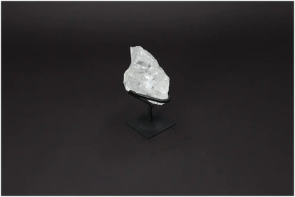 Rough Lemurian Quartz on sleek metal stand, showcasing clear crystal's natural beauty and spiritual allure by Sylvia Crystals.