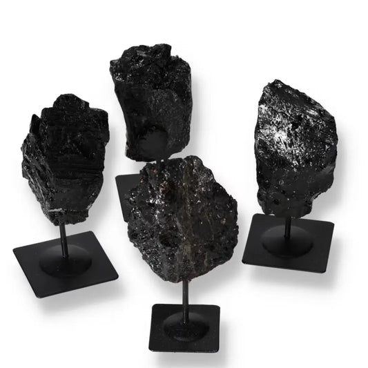 Rough tourmaline stones on metal stands showcasing natural beauty and elegance, available from Sylvia Crystals.