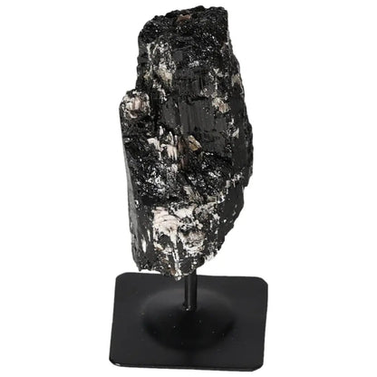 Rough tourmaline crystal on a sleek metal stand from Sylvia Crystals, combining natural elegance with modern design for a sophisticated display.