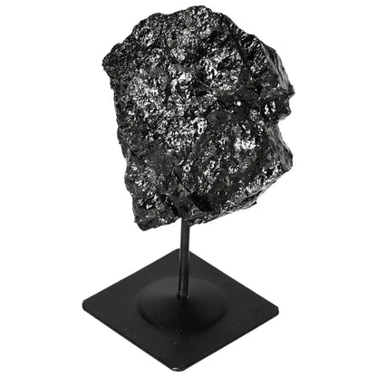 Black rough tourmaline crystal on a metal stand from Sylvia Crystals, showcasing natural beauty and diverse color palette.