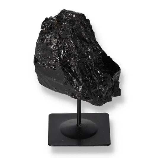 Rough black tourmaline stone on metal stand from Sylvia Crystals, showcasing energy-balancing properties and elegant display.