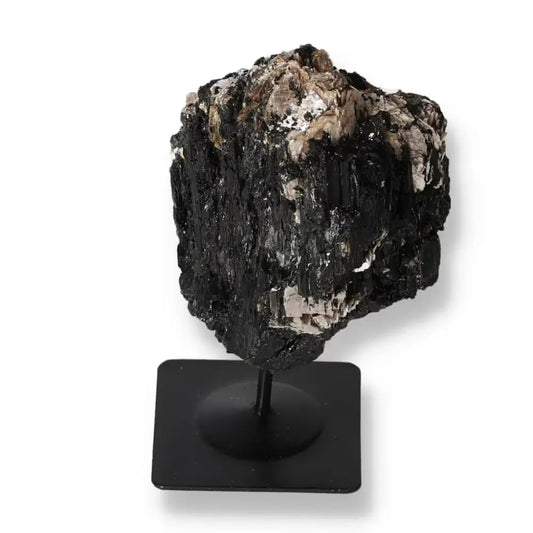 Rough tourmaline crystal on a sleek metal stand, showcasing natural beauty and elegance for interior decoration.