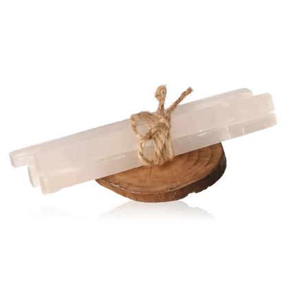 Set of rough selenite sticks tied with twine on a wooden stand, showcasing the mineral's glass-like transparency and natural striations.