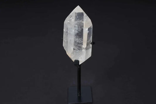 Semi polished clear quartz point on a stand for energy amplification and alignment.