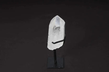 Elegant semi-polished clear quartz point on a sleek stand, ideal for amplifying energy and clarity in meditation spaces.