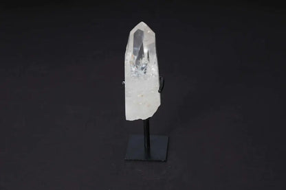 Semi Polished Clear Quartz Point on stand, ideal for meditation, energy work, enhancing clarity and intention, on a dark background.