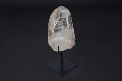 Semi polished clear quartz point on a modern black stand, ideal for energy amplification and meditation.