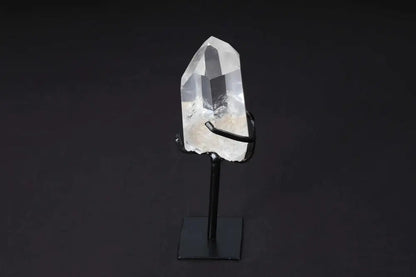 Semi polished clear quartz point on a modern stand for energy amplification and clarity, ideal for meditation and space decor.
