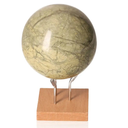 Serpentine Sphere on wooden stand, promoting heart chakra activation and emotional balance for spiritual enlightenment.