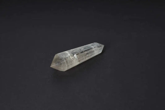 Polished Smoky Quartz point on a dark background, showcasing its translucent, smoky brown tones for grounding and protective energy.