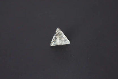 Clear crystal pyramid on a dark background showcasing its geometric shape and reflective surface.