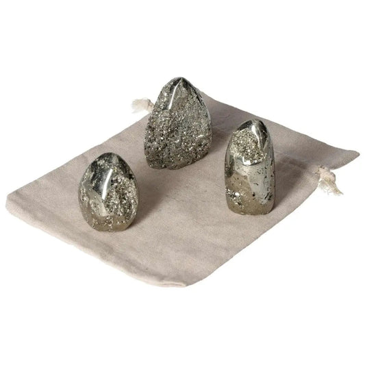 Three superior quality pyrite free form clusters on a cloth, showcasing geometric brilliance and metallic luster.