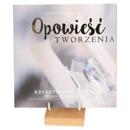 Book titled 'Opowieść Tworzenia' featuring crystals, symbolizing the harmony between heart and mind on a wooden stand.