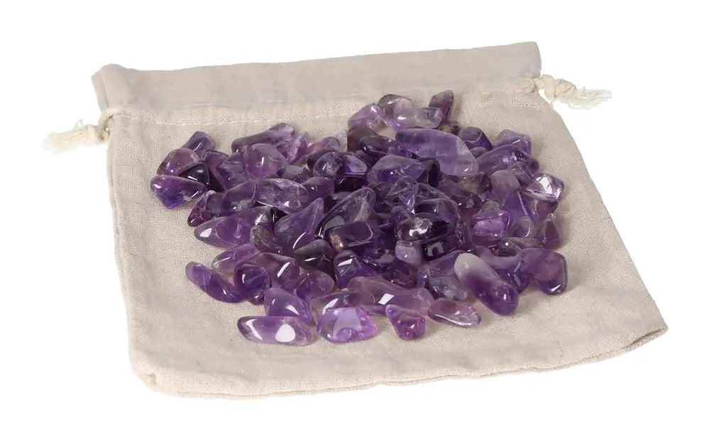 Loose tumbled amethyst stones on a cloth bag for stress reduction, energy boost, and emotional stability.