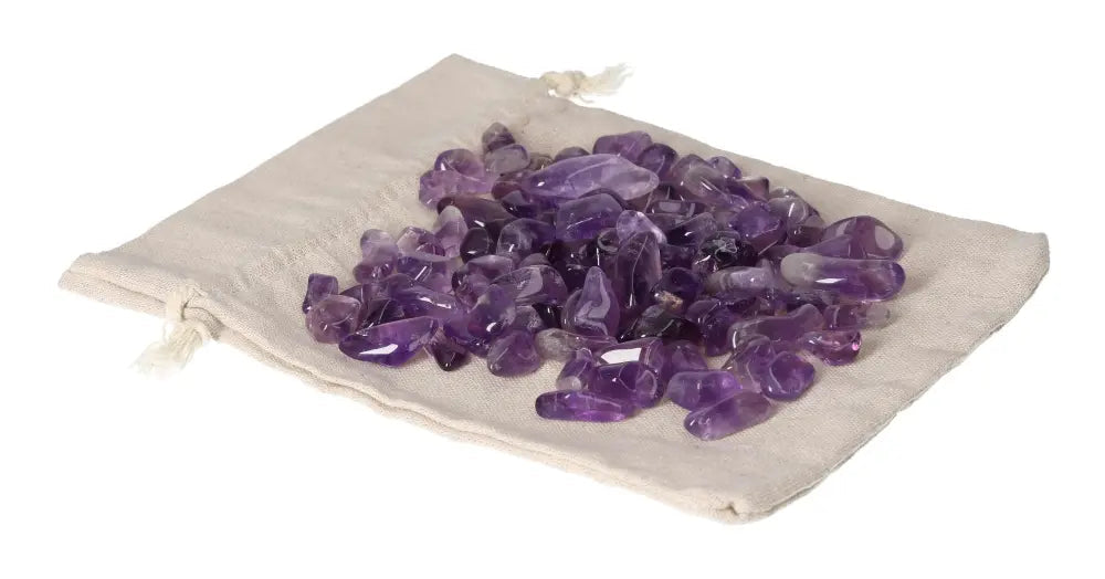 Tumbled amethyst stones on cloth, known for reducing stress, boosting energy, enhancing concentration, and emotional stability.