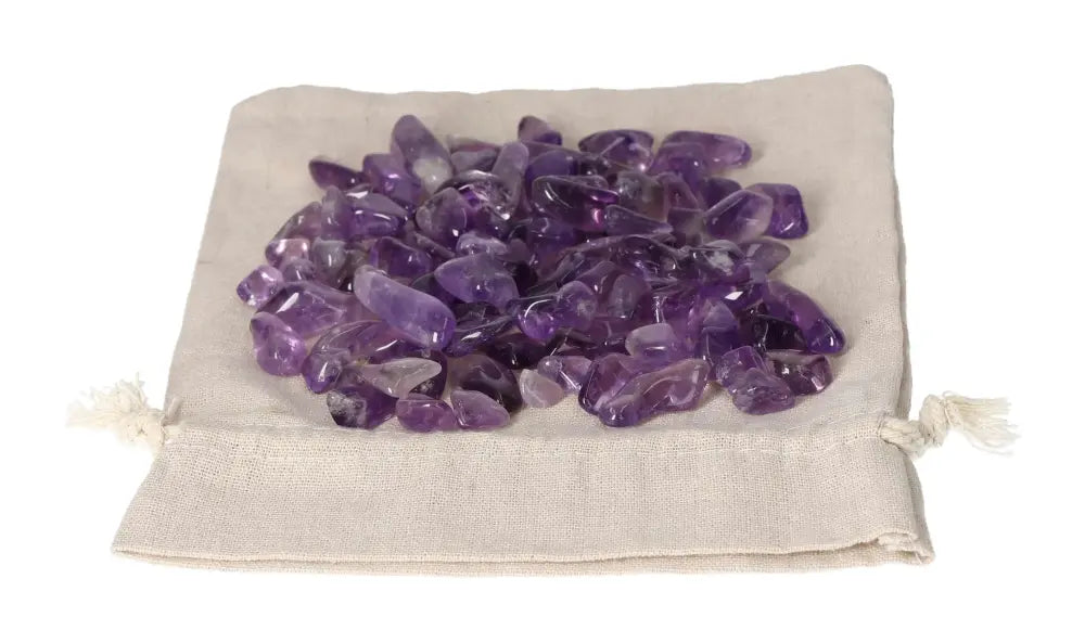 Tumbled Amethyst stones on a beige pouch, offering stress reduction, energy boost, and emotional stability benefits.