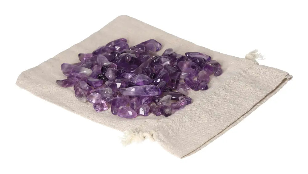 Tumbled amethyst stones on a beige fabric pouch, known for reducing stress, boosting energy, enhancing concentration, and emotional stability.