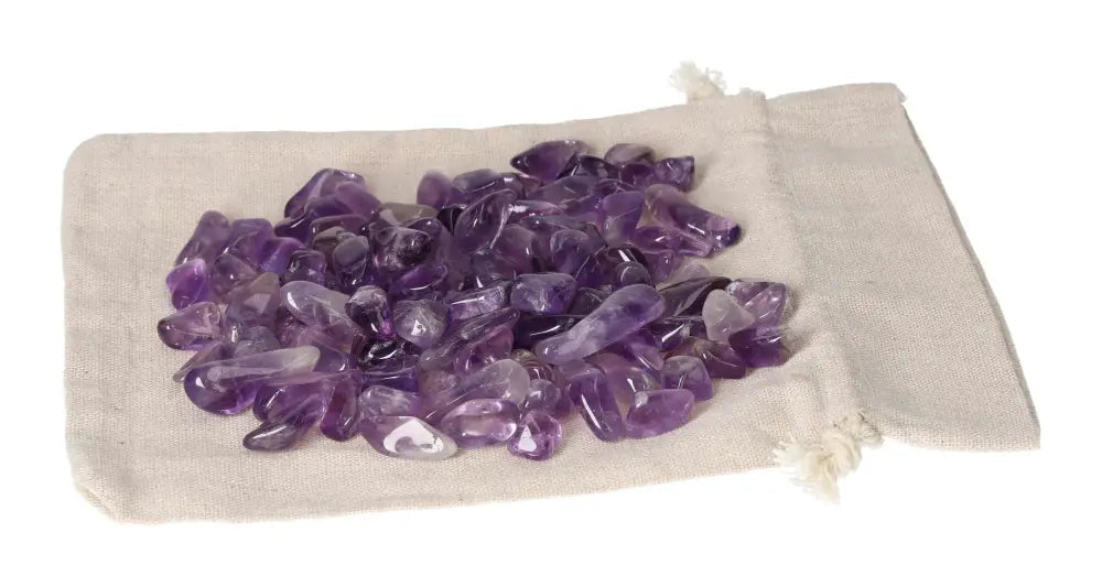 Tumbled amethyst stones on a beige cloth pouch, ideal for stress reduction, energy boost, concentration, and emotional stability enhancement.