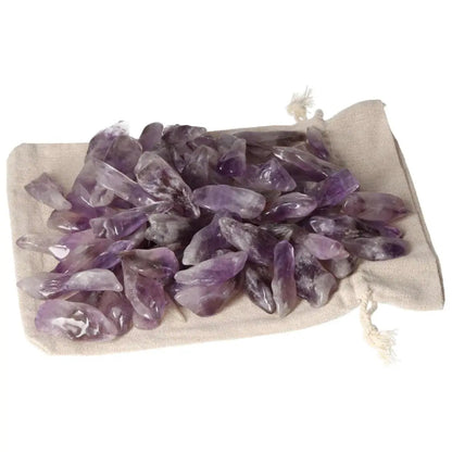 Tumbled Amethyst stones on a beige pouch showcasing deep purple hues and white veins, ideal for enhancing energy flow and tranquility.