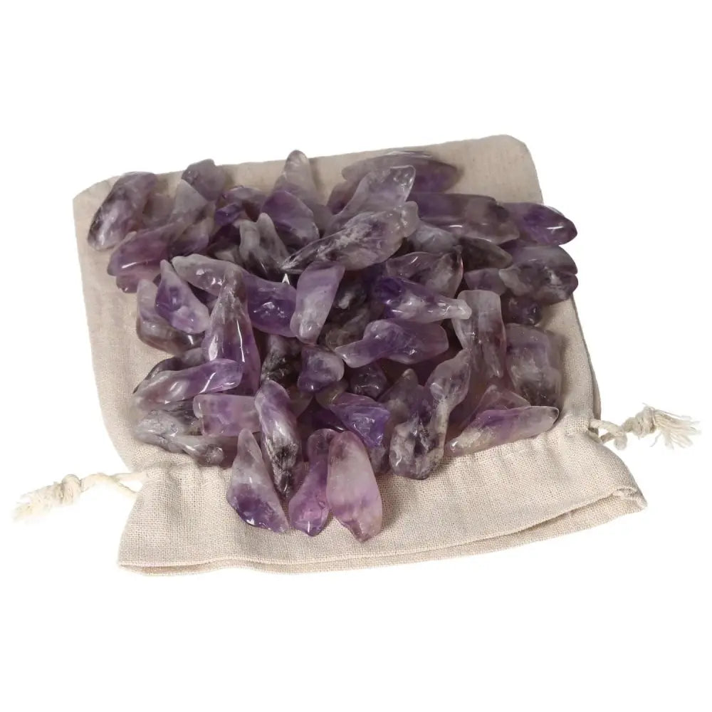 Tumbled Amethyst gemstones on a beige cloth, featuring vibrant purple hues and subtle white veins, enhancing tranquility.