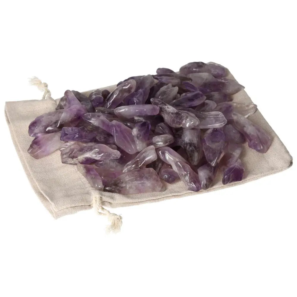 Assorted tumbled amethyst stones on linen pouch showcasing deep purple hues and white veins, available at Sylvia Crystals.