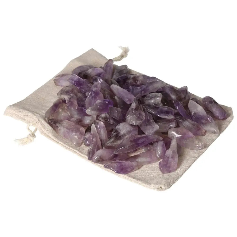 Tumbled Amethyst stones on a linen pouch, showcasing deep purple hues and white veins, ideal for stress relief and energy flow.