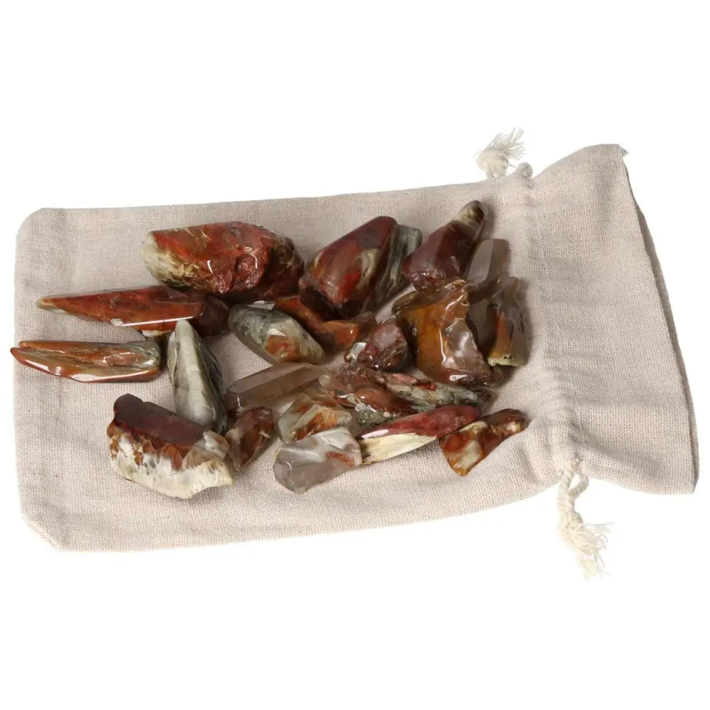 Handpicked Tumbled Amphibole crystals from Sylvia Crystals, showcased on a soft beige pouch, radiating captivating energy and allure.