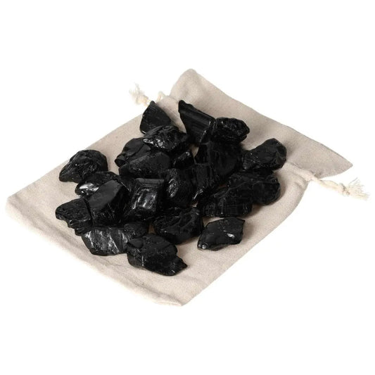 Tumbled Black Tourmaline stones on a beige cloth, part of Sylvia Crystals' 1KG 20PCS set, known for grounding and energy cleansing.