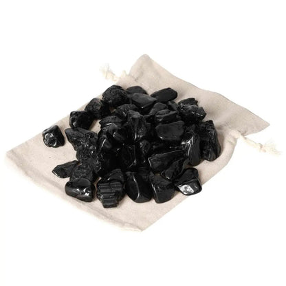 Tumbled Black Tourmaline stones on a beige cloth, premium quality, 1KG, 50 pieces from Sylvia Crystals.