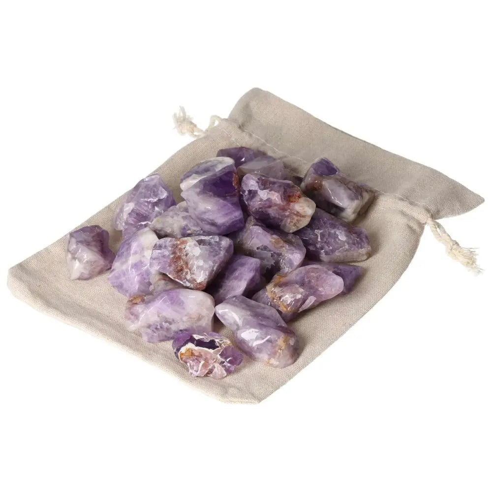 Tumbled Chevron Amethyst stones from Sylvia Crystals on a cloth bag, showcasing deep purple and white bands, symbolizing spirit and matter.