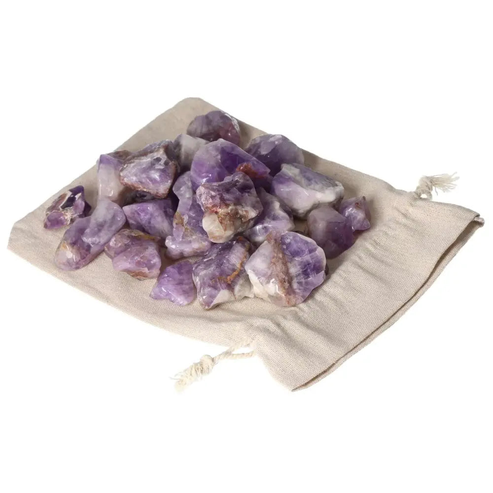 Tumbled Chevron Amethyst stones on a drawstring pouch, showcasing deep purple and white bands, from Sylvia Crystals.