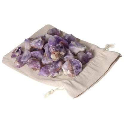 Tumbled Chevron Amethyst stones on a drawstring pouch, showcasing deep purple and white bands, from Sylvia Crystals.