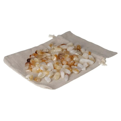 Tumbled citrine with quartz stones on a beige drawstring bag, promoting inspiration, wealth, and a positive outlook.