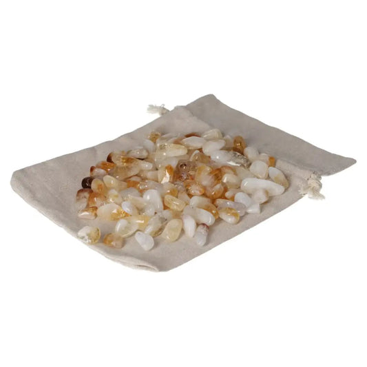 Tumbled citrine with quartz stones on a beige drawstring bag, promoting inspiration, wealth, and a positive outlook.
